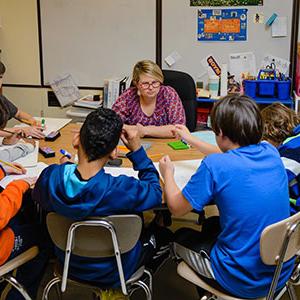 teacher with students at table